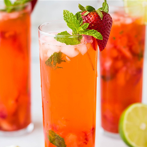 Tall glasses of Lemon Raz garnished with strawberries, lime and mint