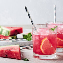 Two watermelon margaritas with striped straws